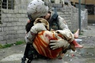 U.S. Soldier carrying child.